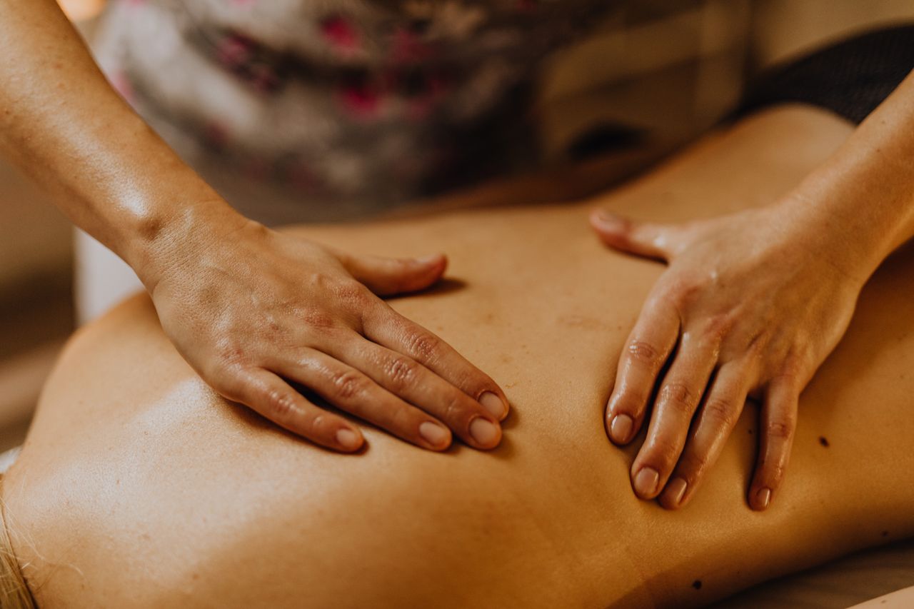 Home Close-up of hands giving a soothing back massage in a calm setting.